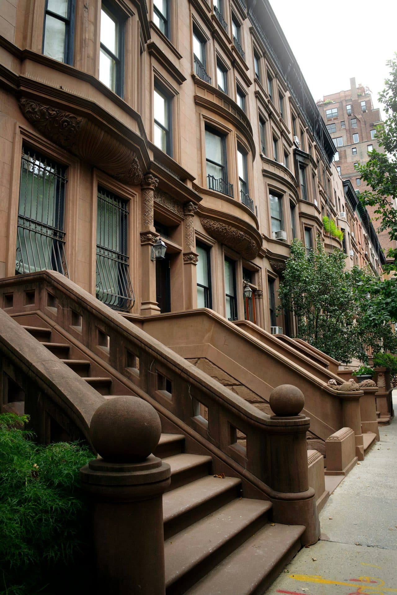 Brownstone row houses with ornate front stoops