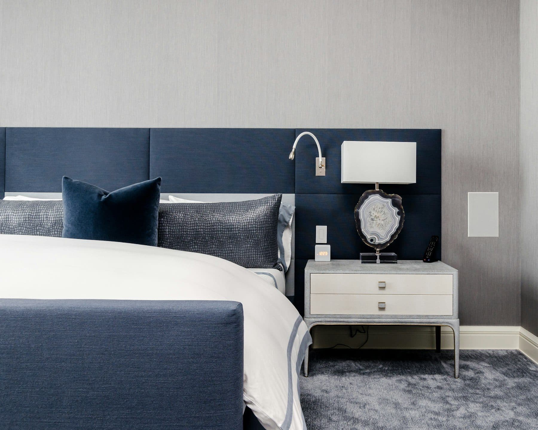 A refined navy and ivory primary bedroom with a tufted headboard